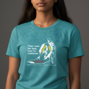 Person wearing a teal Our Lady of Guadalupe T-shirt on a gray background.