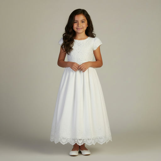 A young girl wearing a white lace Communion dress on a neutral background