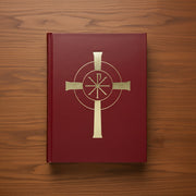 Red liturgical book with a gold cross on a wood background