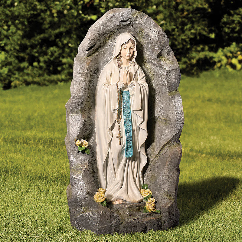 Statue of a religious figure in a natural setting with greenery