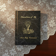 Black book titled 'Remembrance of My First Holy Communion' on a lace tablecloth