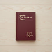 Maroon Confirmation Book with 'Saint Joseph' text on a light wooden surface