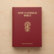 Red New Catholic Bible on a wooden surface