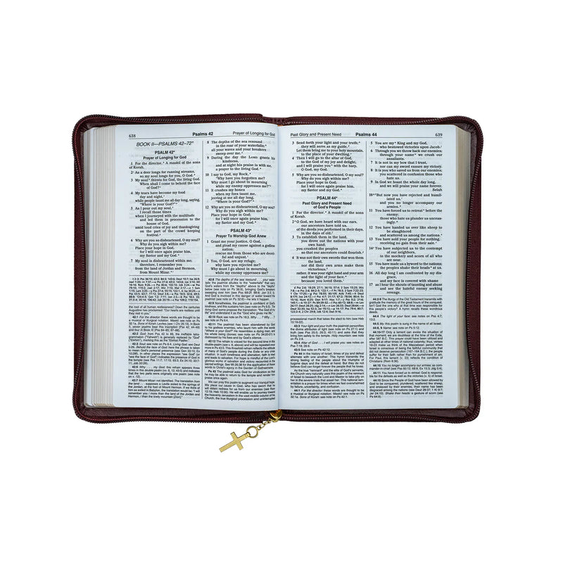 Open Bible inside a brown leather cover with a gold cross charm on a white background