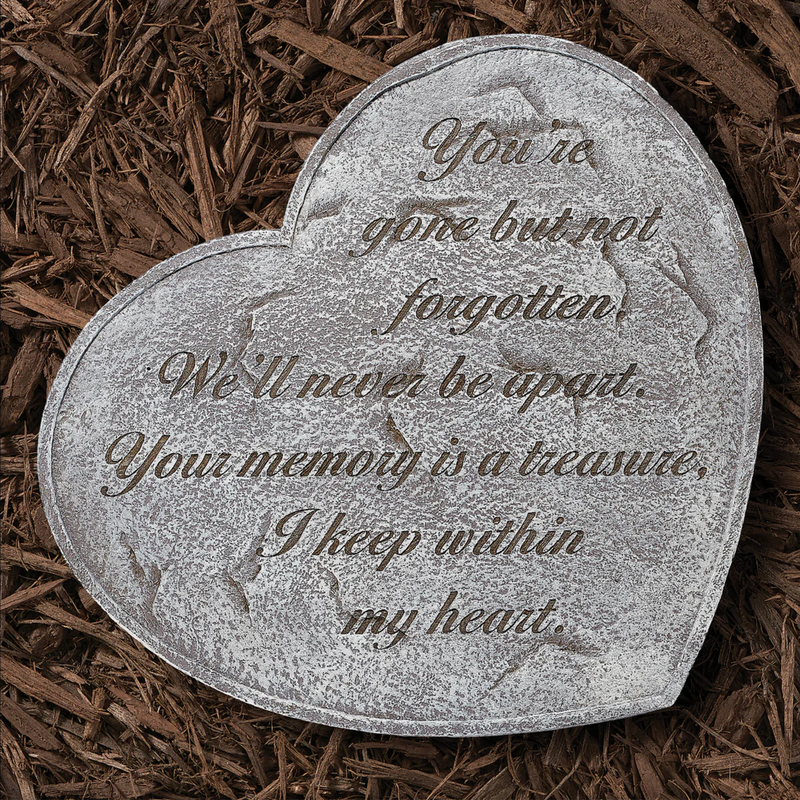 Heart-shaped memorial stone with engraved text on a bed of wood chips
