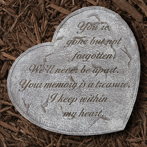 Heart-shaped memorial stone with engraved text on a bed of wood chips