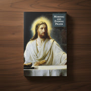 Booklet with an illustration of Jesus in white robes on the cover, titled 'Morning and Evening Prayer' on a wood background.