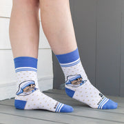 A person in white socks with blue accents and an image of Mother Teresa