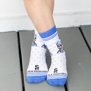 A person in white socks with blue accents and an image of Mother Teresa