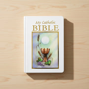 White Bible with 'My Catholic Bible' text and chalice illustration on a wooden surface