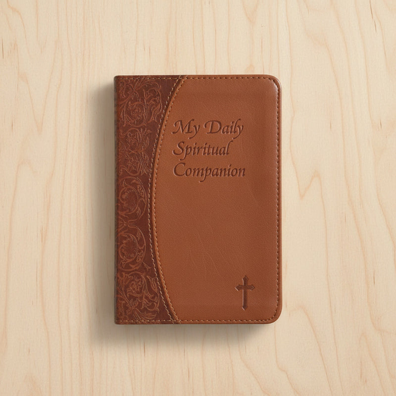 Brown leather book with 'My Daily Spiritual Companion' text on a wooden surface