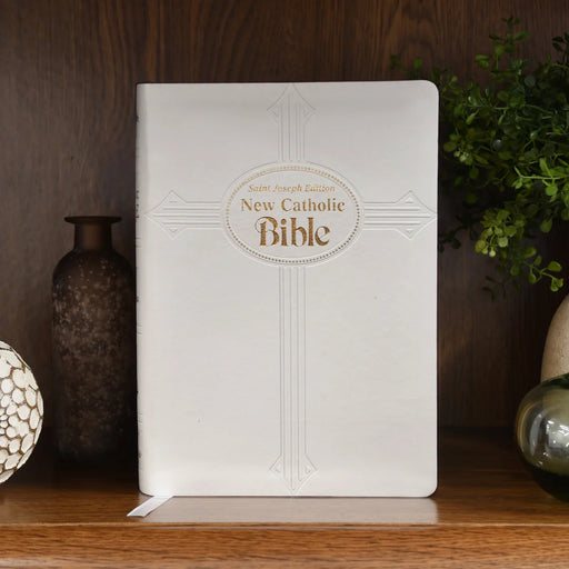 White New Catholic Bible on a wooden surface with decorative elements