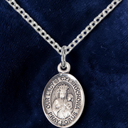 Silver pendant necklace on a dark blue fabric background