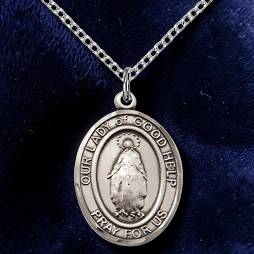 Silver religious pendant on a chain against a dark blue background