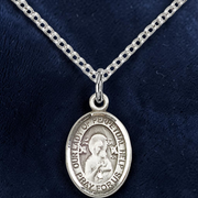 Silver religious pendant necklace on a dark blue background