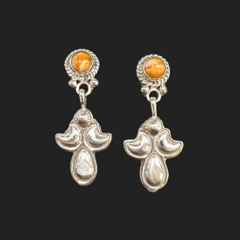 A pair of sterling silver earrings with orange turquoise gemstones on a black background