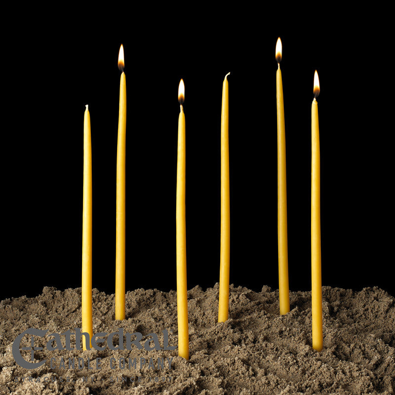 Yellow candles in soil with a black background