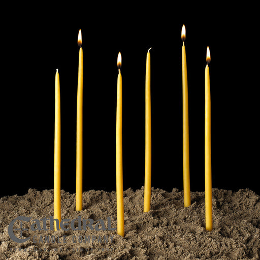 Yellow candles in soil with a black background
