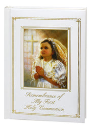 Memorabilia album with a young girl in a white dress and veil, praying, and text 'Remembrance of My First Holy Communion'.