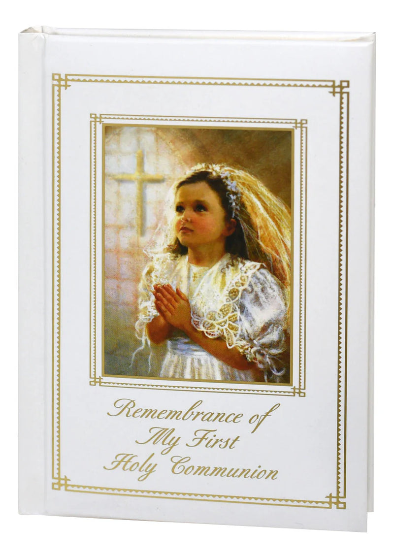 Memorabilia album with a young girl in a white dress and veil, praying, and text 'Remembrance of My First Holy Communion'.