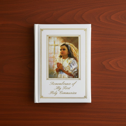 Book titled 'Remembrance of My First Holy Communion' with a portrait of a young girl on a wooden surface