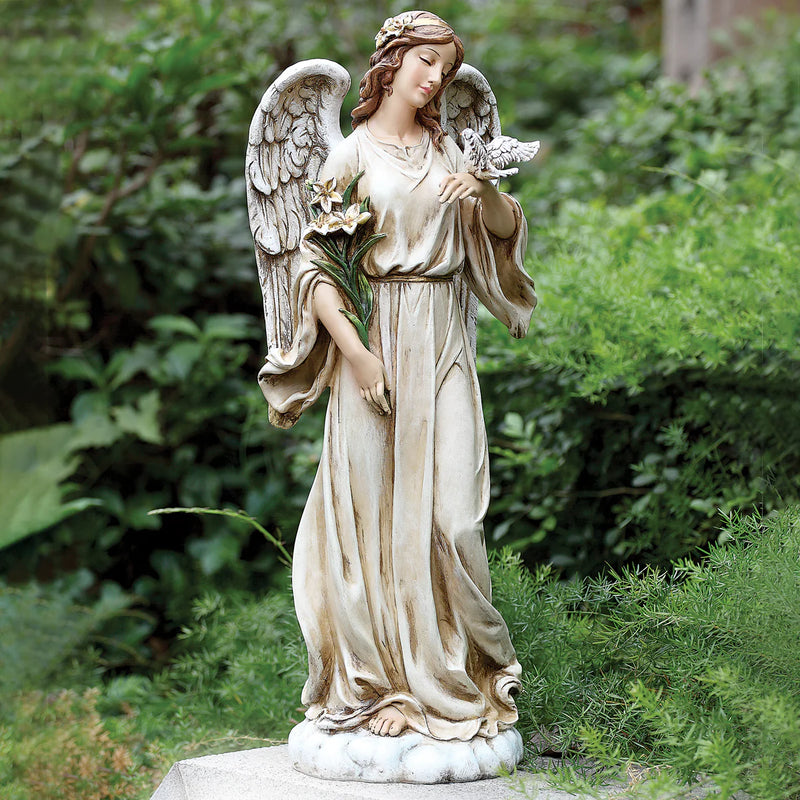 Statue of an angel holding a child in a garden setting