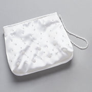 White Communion handbag with pearl embellishments on a gray background