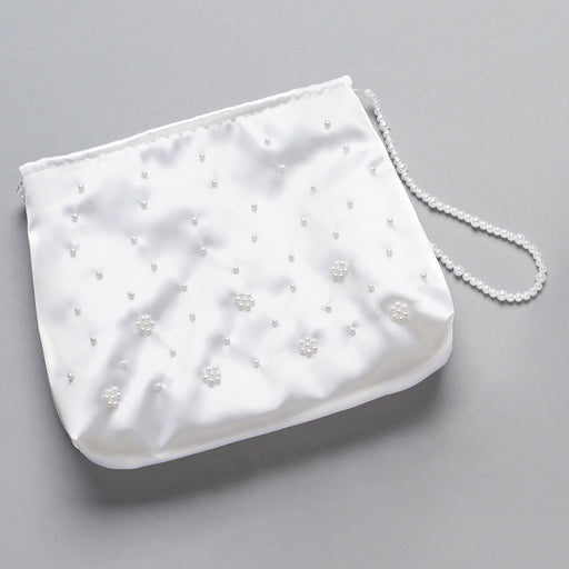 White Communion handbag with pearl embellishments on a gray background