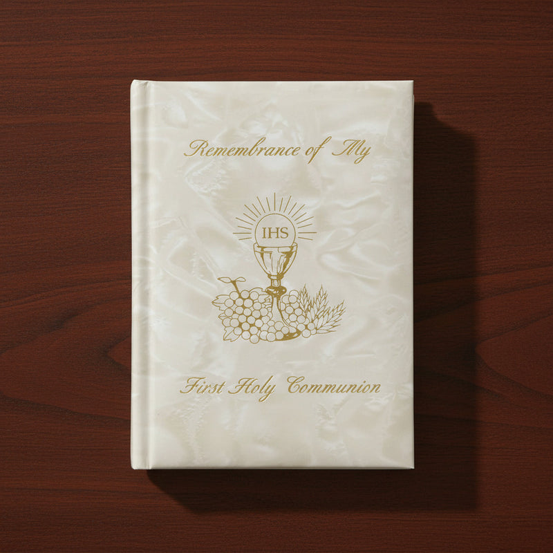 White pearlized Communion book with gold text and design on a wooden surface