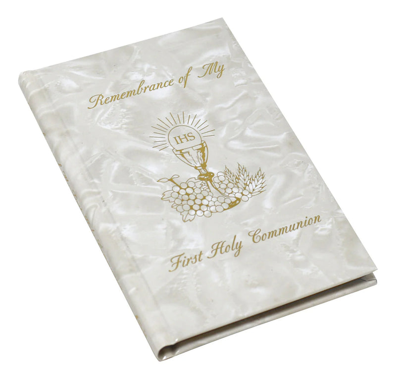 White book with gold text and design, likely for First Holy Communion, on a white background