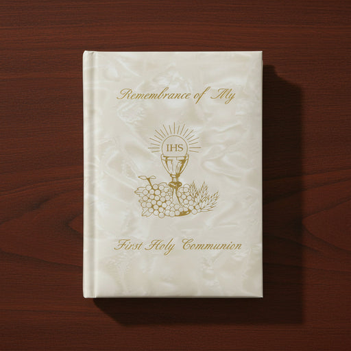 White pearlized Communion book with gold text and design on a wooden surface