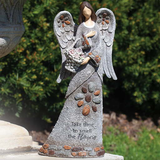 Stone angel statue holding flowers with a garden background