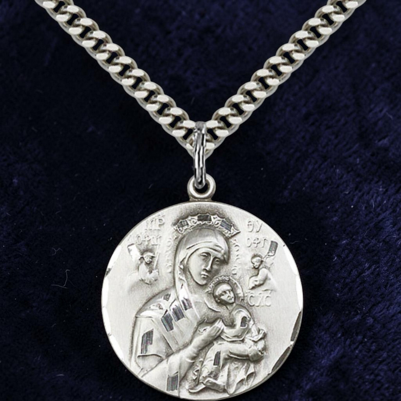 Silver necklace with a pendant featuring an engraved design on a dark blue background