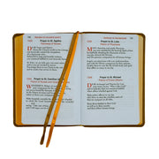 Open book with prayer text and a pen on a white background