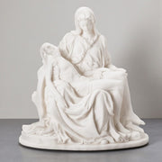 White marble sculpture of the Pieta on a gray background