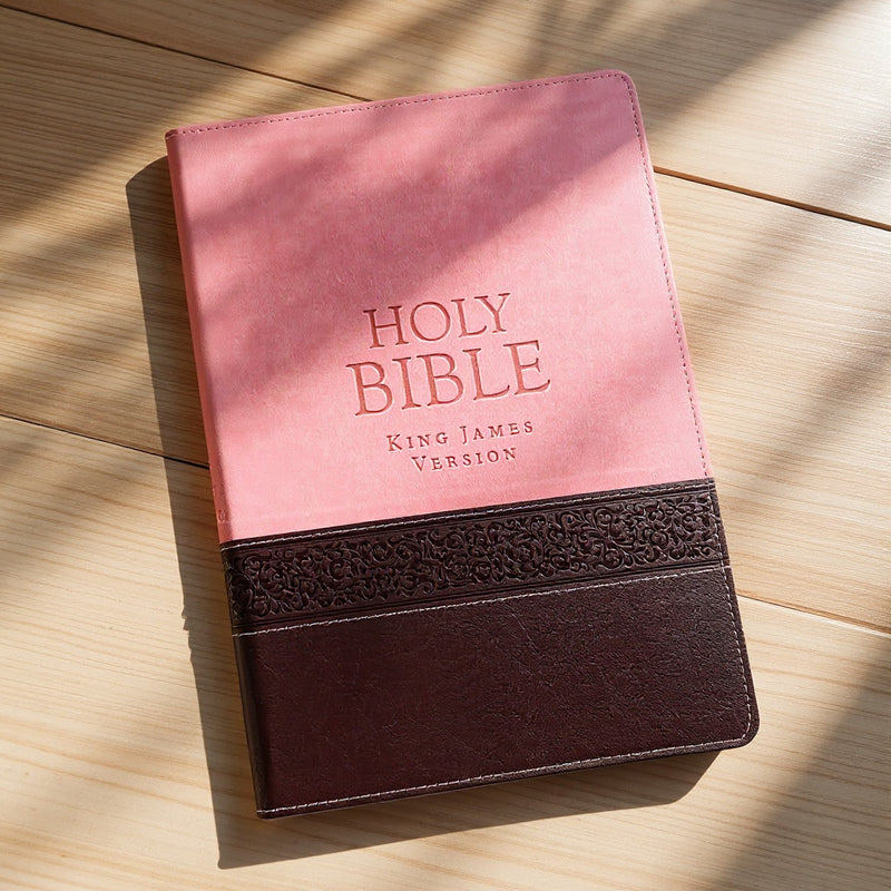 Pink and brown Bible with 'HOLY BIBLE King James Version' text on a wooden surface