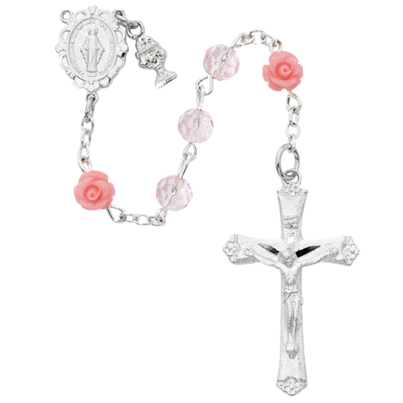 A pink crystal First Communion rosary in a white box, with rose Our Father beads and a pewter Miraculous Medal centerpiece.