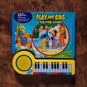 Children's toy keyboard with 'Play and Sing to the Lord' book on a wooden surface
