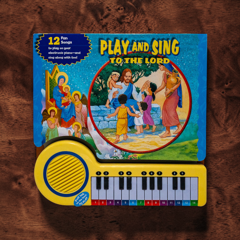 Children's toy keyboard with 'Play and Sing to the Lord' book on a wooden surface
