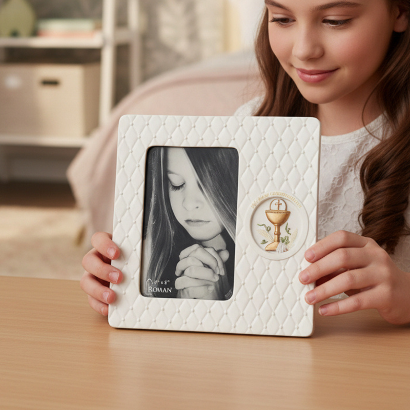 Girl holding a white photo frame with a picture of a praying child and a First Communion chalice emblem.