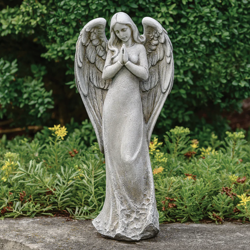 Statue of an angel praying in a backyard