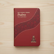 Red book titled 'Psalms' from the New Catholic Version on a wooden surface