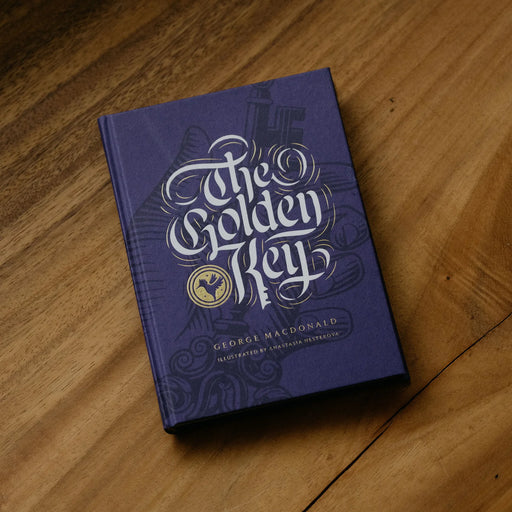 Purple children's book titled 'The Golden Key' on a wood surface.