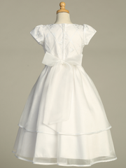 Rear view of a white First Communion gown over a gray background.