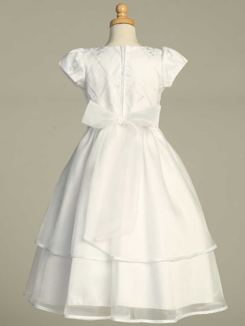 Rear view of a white First Communion gown over a gray background.