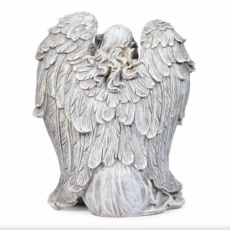Statue of an angel with detailed wings on a white background