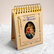 Desk calendar titled 'The Illustrated 365 Rosary' on a marble surface
