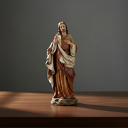 Statue of a religious figure in a warm-toned robe on a dark background