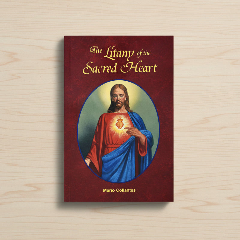 Red paperback book entitled 'The Litany of the Sacred Heart' on a light wood background.