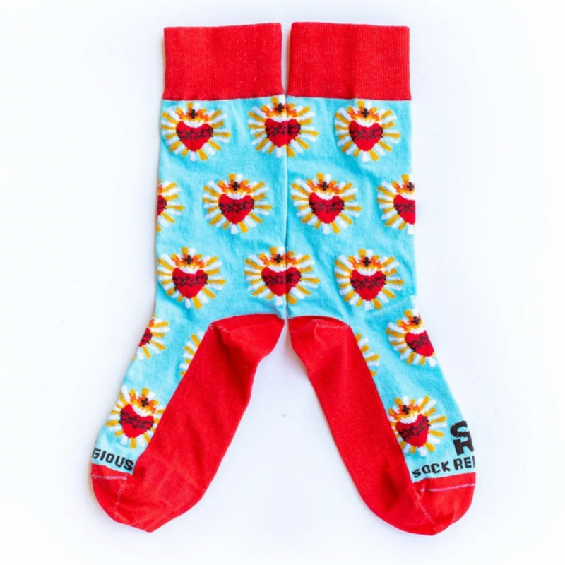 A pair of adult-sized socks with a design of the Sacred Heart of Jesus, predominantly red with blue and yellow accents.